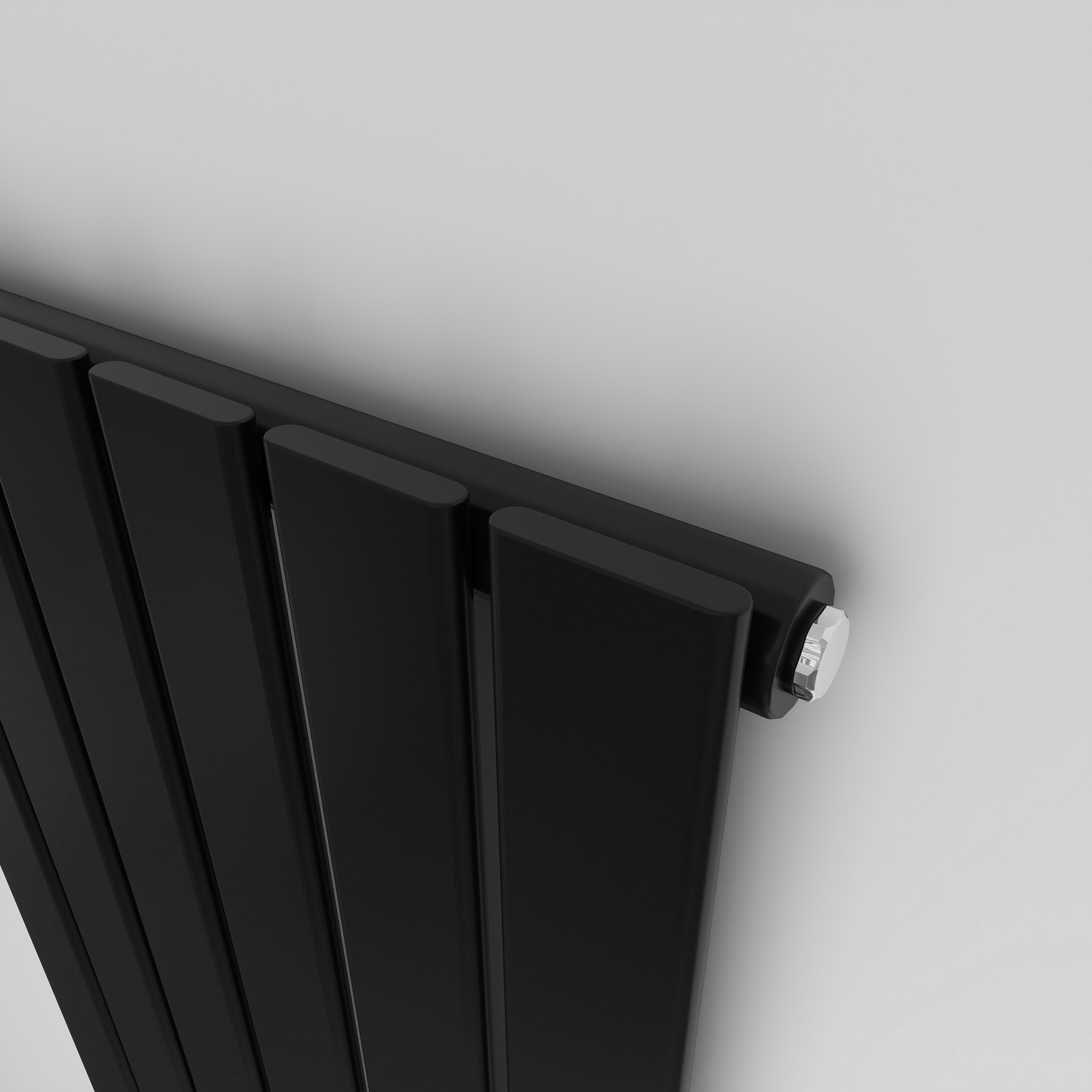Close-up of an Black Single Flat Panel Radiator with Valves, showing the Cast Iron Tube Detail.